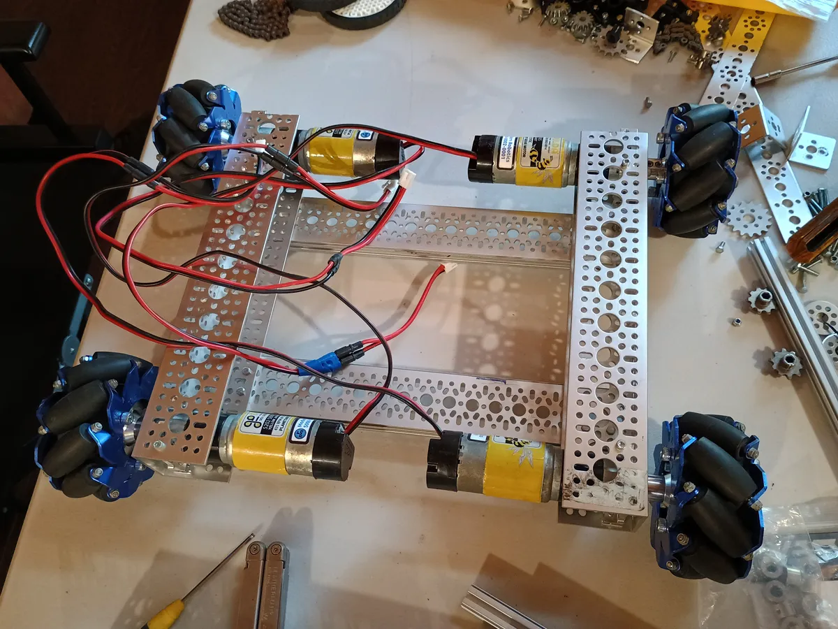 The new chassis frame during assembly, with four mecanum wheels and drive motors on a work table