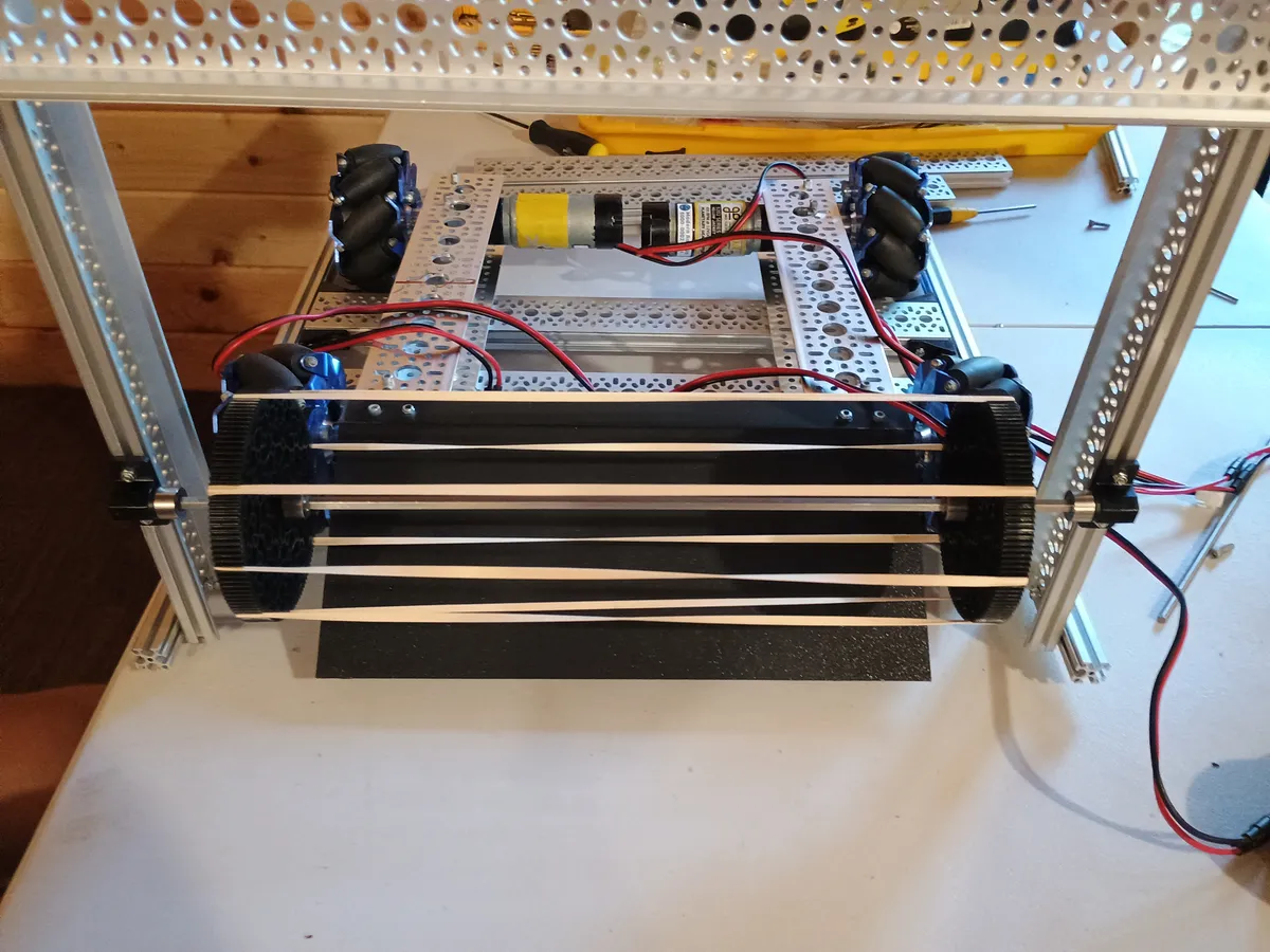 The rubber band intake roller mounted between two uprights in front of the chassis, above the ramp